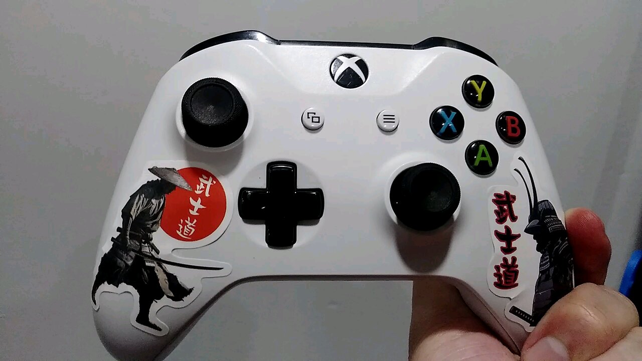 Decorating my Xbox controller with samurai stickers by Jack the Irish wolfhound