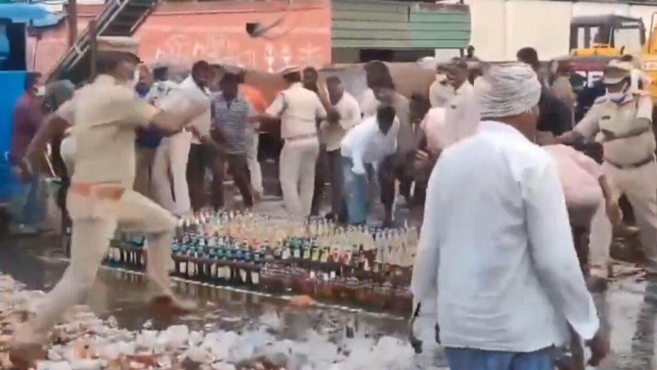 Locals grab Liquor Bottles during Police Disposal of seized Alcohol