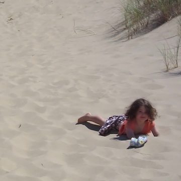 "Tot Girl Run Down Sand Dunes, But Trips Face Plants Into The Sand"