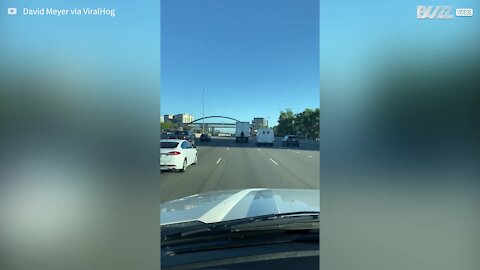 Cet homme se fait transporter à l'arrière d'un camion