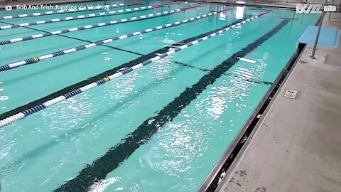 Guy juggles while swimming