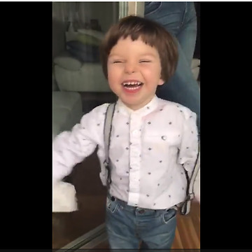 Toddler blows raspberries to help clean the windows