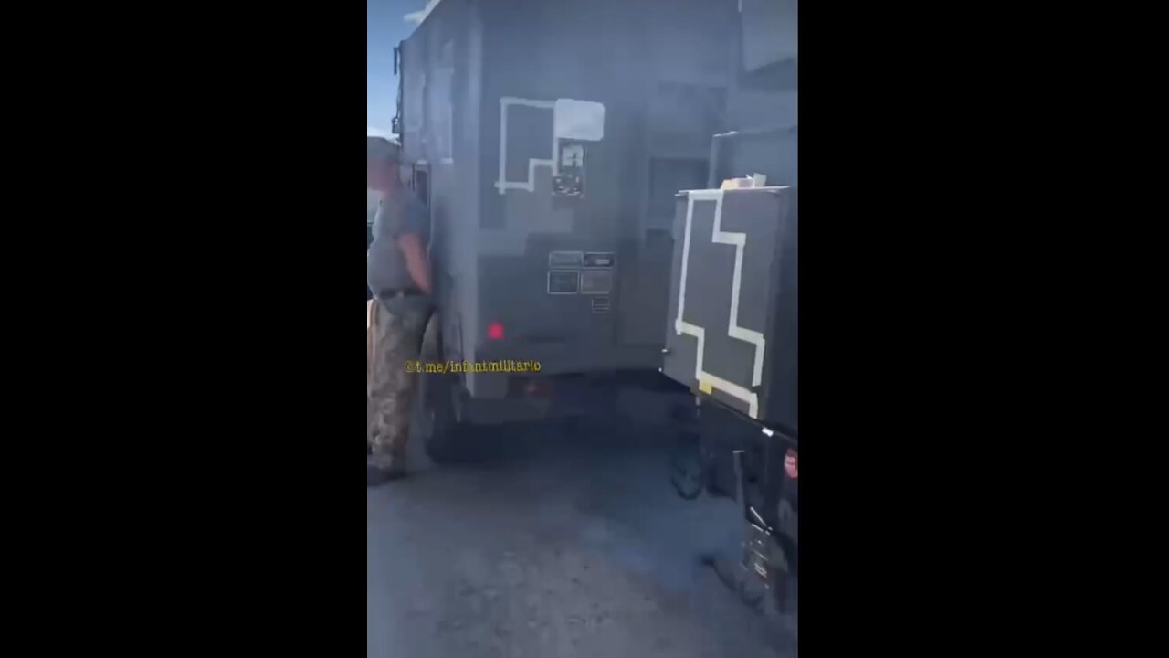 Ukrainian servicemen apply camouflage to vehicles transferred by the American army