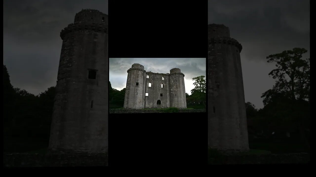 Nunney Castle with rain storm coulds above