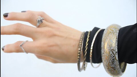 A Woman Hand Wearing Arm Bracelets And Finger Rings