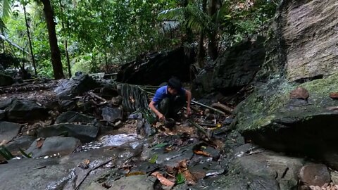 Building a bamboo shelter on a rock face:3