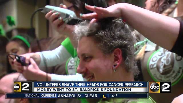 Volunteers shave their heads for childhood cancer research