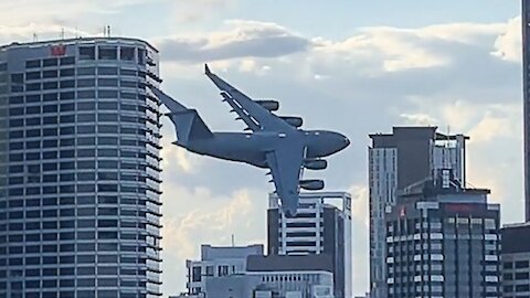 Plane Flies Between Buildings