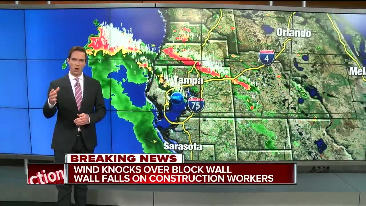 Wind knocks block wall onto construction workers