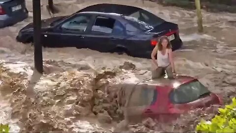 Woman gets to the top of the car to save her life amid massive flooding in Zaragoza...