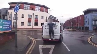 Uomo si aggrappa a un furgone in movimento!