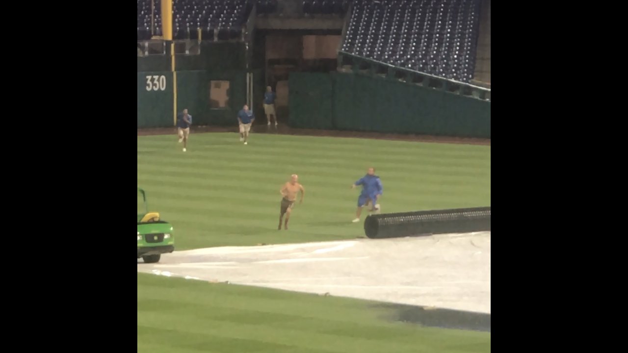 Man runs onto baseball field during ran delay, slides on water-filled tarp