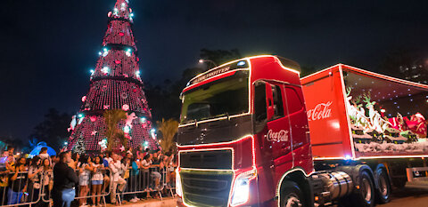 Coca-cola truck passing by with Santa Claus.