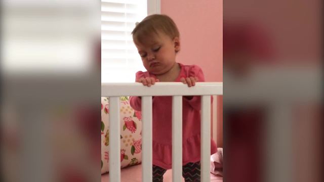 "A Tot Girl Sleeps Standing Up in Her Crib"