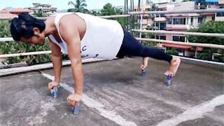 Homem faz flexões apoiado em latas