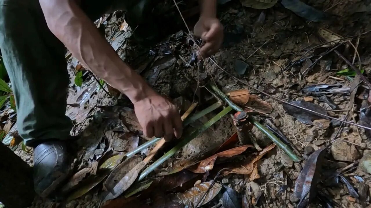 Building a bamboo shelter on a rock face:8