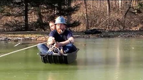 Deux hommes tentent de faire de la luge sur un lac gelé