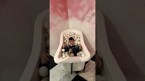 Cute Boy In Bathtub Filled With Balls