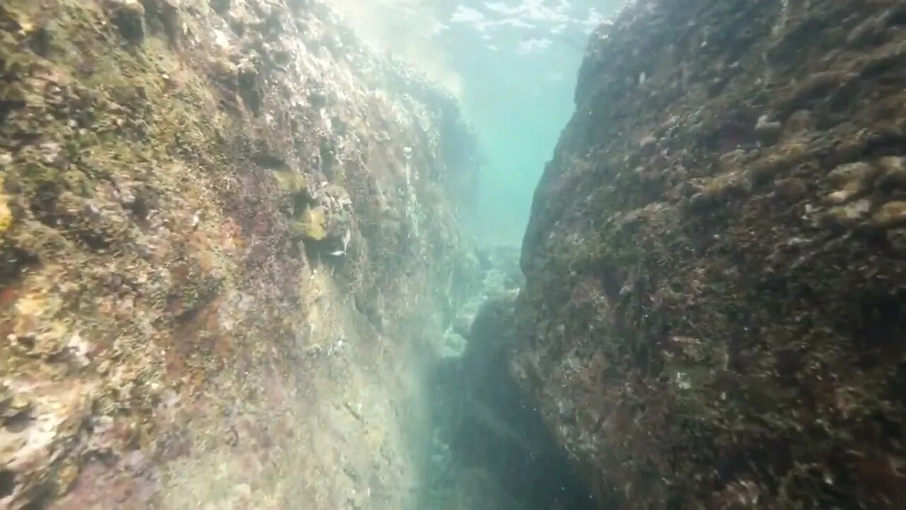 Underwater scene Camera moving through a passage between big rocks