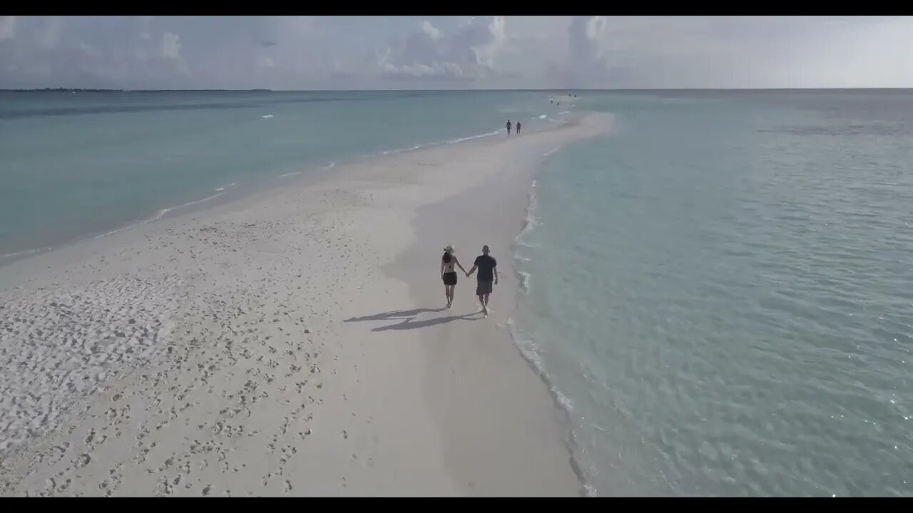 Couple Walking on a Beach Filmed with a Drone