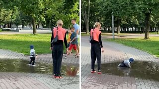 Happy Toddler Plays In Giant Puddle At The Park