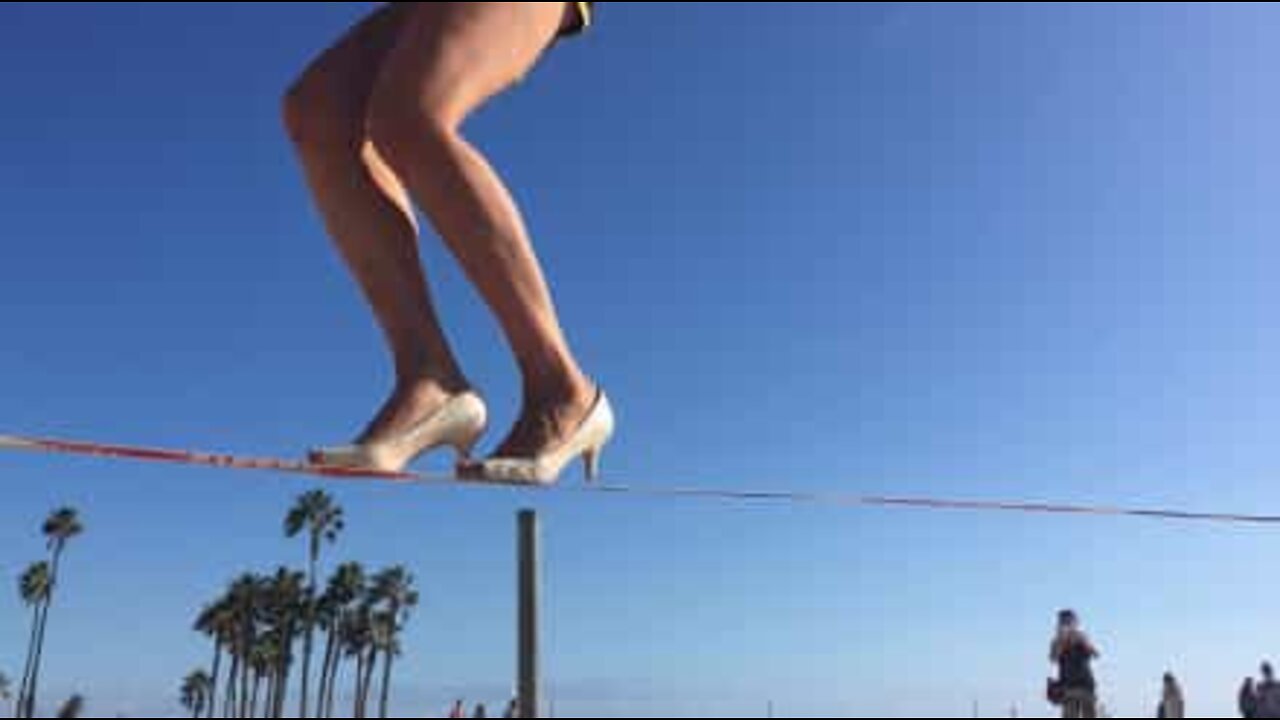 En amerikansk atlet står på slackline i høje hæle!