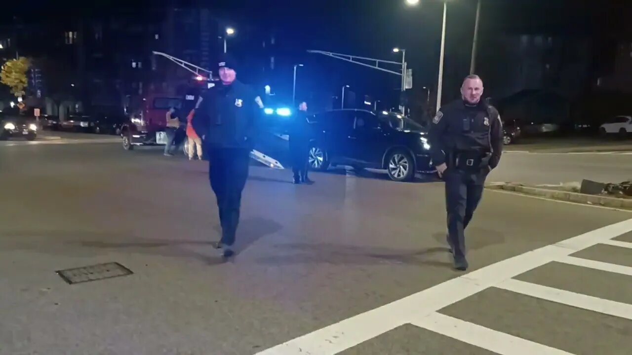 Boston police directing traffic after car takes out light Pole.