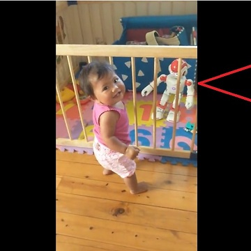 Baby dances along to toy robot
