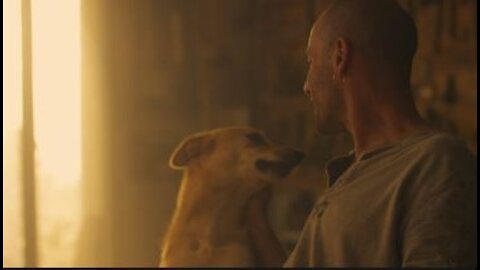 man kissing and petting his dog in workshop.