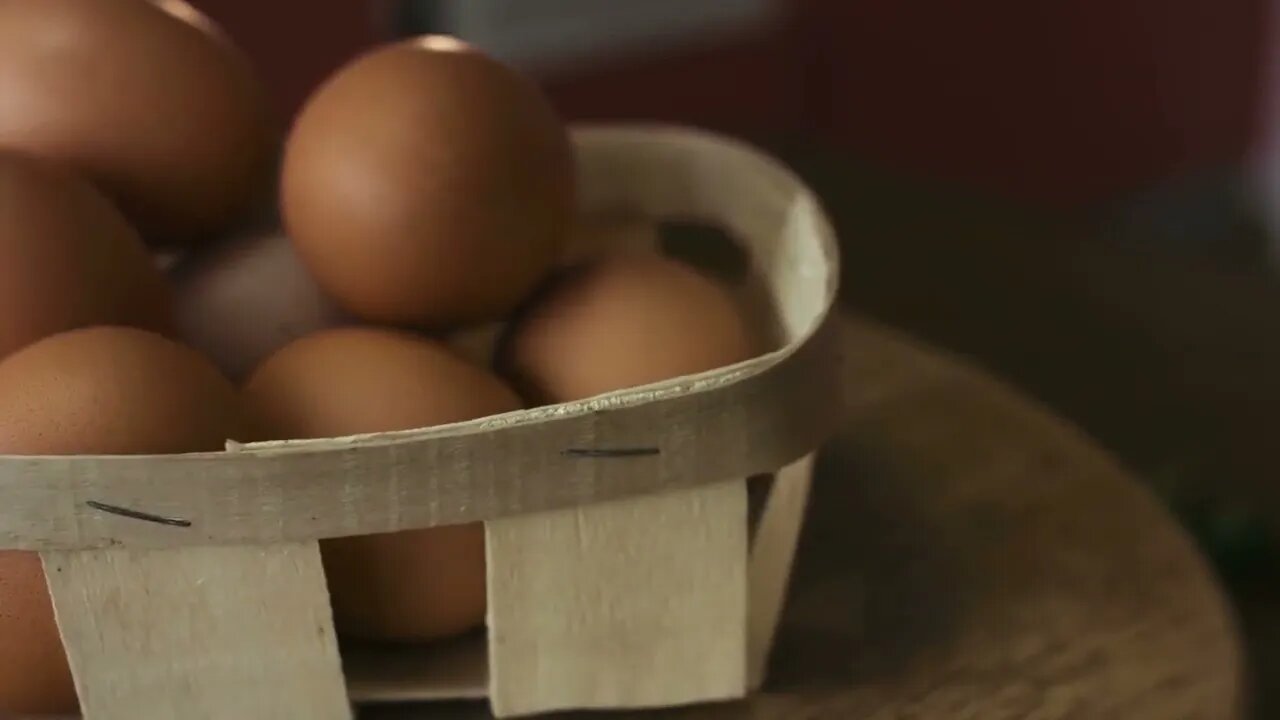 Close-up footage of basket of brown eggs lie on a wooden board which is spinning around