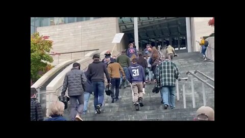 Seattle police and firefighters walking up Seattle City Hall to turn in their boots.