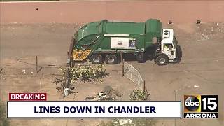 2 trapped after garbage truck hits power pole