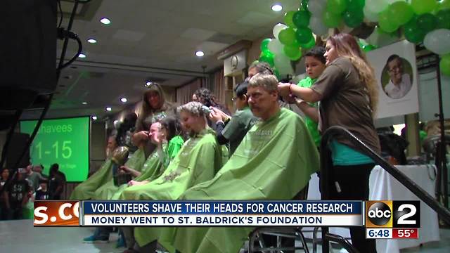 Volunteers shave their heads for childhood cancer research