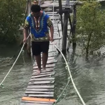 A Man Falls Off A Small Rickety Bridge