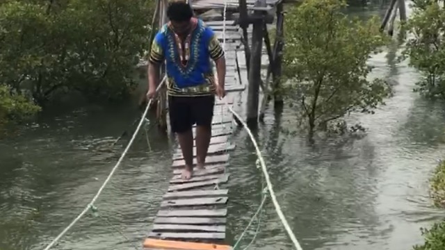 A Man Falls Off A Small Rickety Bridge