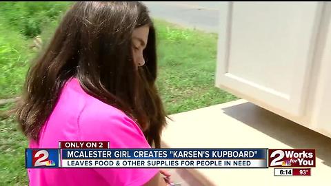 Young girl opens food cupboard for community