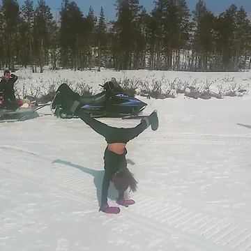 A Young Girl Does Several Cartwheels In A Row On The Snow