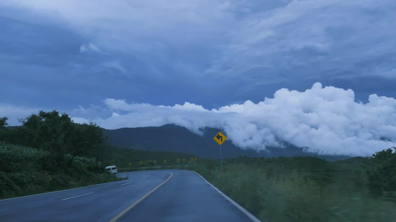 Going down a curved highway through a mountain range