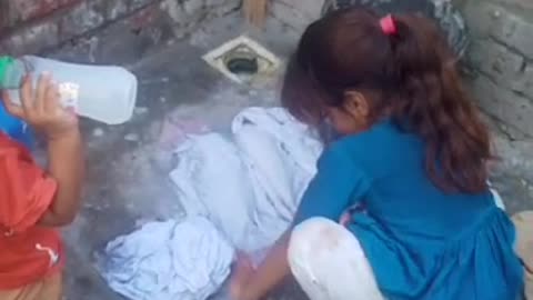 Little girls wash clothes