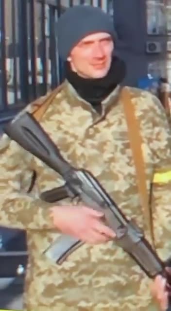 Humor - Soldado distraído com a arma no fundo da reportagem