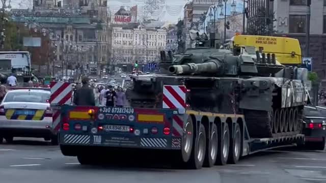 Ukrainian Soldier watching Russian Tank being towed