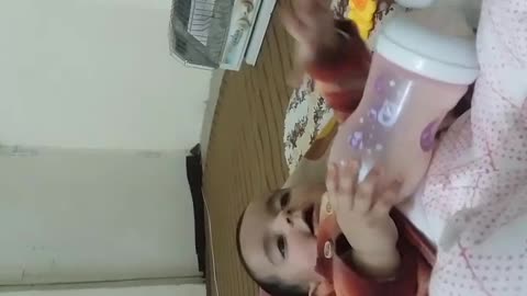 Cute baby talking with grandfather and feeding milk