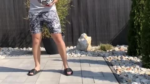 Man Performs Tricks by Bouncing Bottle off Ball and Catching It