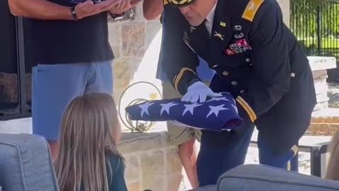 A Colonel presenting the flag to his grandnieces. Honoring the service and