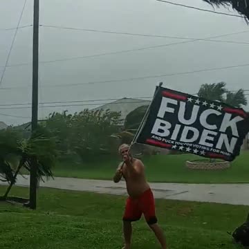 Man in Florida holding anti-Biden flag as Hurricane Ian approaches