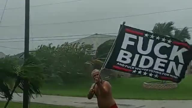 Man in Florida holding anti-Biden flag as Hurricane Ian approaches