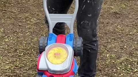 Little Girl Grips Onto Lawnmower Toy Tightly