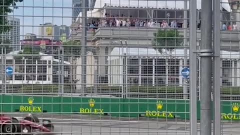 People stand outside Fl circuit fencing to watch for free