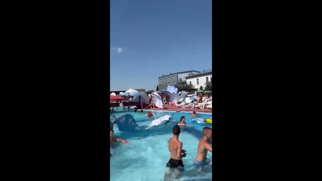 Flying umbrellas in the wind wreak havoc at the pool