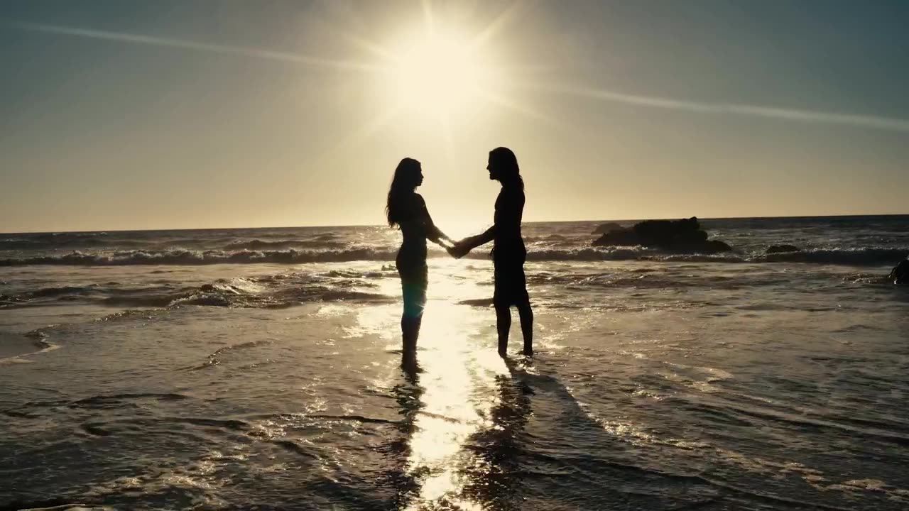 couple holding hands on the beach